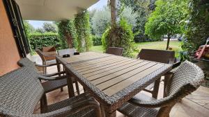 a wooden table and chairs on a patio at Tiber Domus Trevignano in Trevignano Romano