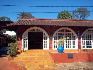un edificio rojo con un jarrón azul delante de él en Posada Iguazu Royal en Puerto Iguazú