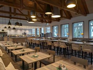 a restaurant with wooden tables and chairs and a bar at BSW Hotel Isarwinkel in Bad Tölz