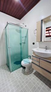 a bathroom with a shower and a toilet and a sink at Casa na serra in Campos do Jordão +12 photos