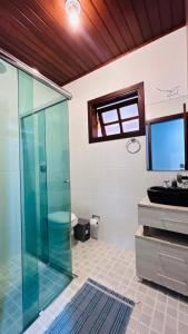 a bathroom with a glass shower and a sink at Casa na serra in Campos do Jordão