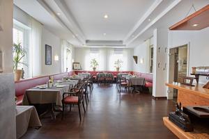 a restaurant with tables and chairs in a room at Hotel Zur Wartburg in Rheda-Wiedenbrück