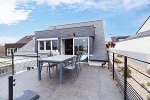 a patio with a table and chairs on a balcony at Maison avec terrasse proche plage et port de Binic in Binic-Etables-sur-Mer +30 photos