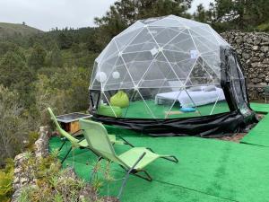 a tent with a chair and a bed in it at SkyDome in San Juan del Reparo
