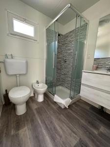 un bagno con wc e doccia in vetro di Campeggio Punta di Crabbia a Pettenasco Altre 37 foto