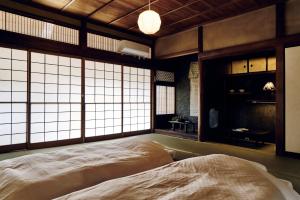 平群町natomi宿的一间带窗户的房间里有一张大床的卧室