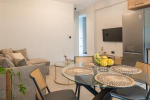a living room with a table with chairs and a refrigerator at Callas Home in Kos