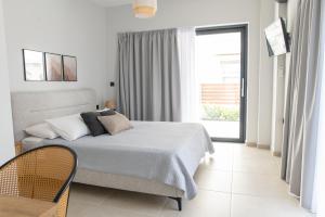 a bedroom with a bed and a large window at Callas Home in Kos