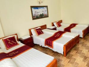 a group of four beds in a room at Công Thành Hotel in Lao Cai