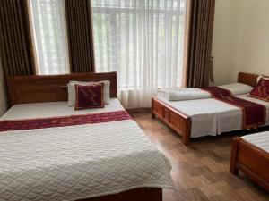 a bedroom with two beds and a window at Công Thành Hotel in Lao Cai