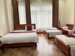 a bedroom with three beds and a window at Công Thành Hotel in Lao Cai +6 photos