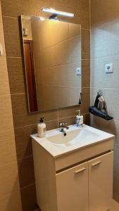 ein Badezimmer mit Waschbecken und großem Spiegel in der Unterkunft Almeida's House by Férias em Figueira in Figueira da Foz