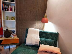 a living room with a green couch and a lamp at Le Figuier appart 2-3 pers en plein vignoble avec piscine privée à 30mn des gorgesdu Verdon et des plages in Carcès