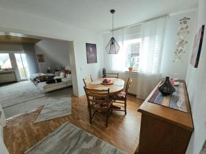 a kitchen and living room with a table and chairs at Gemütliche Dachgeschoßwohnung mit Balkon in Dortmund in Dortmund