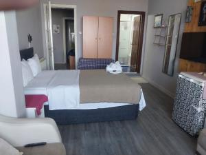 a hotel room with a large bed and a chair at Palmiye Pansiyon in Adalar +5 photos