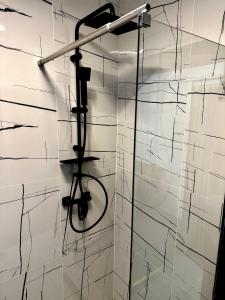Eine Dusche in einem Badezimmer mit schwarz-weißen Fliesen in der Unterkunft Hotel Palace in Târgu Jiu + 31 Fotos