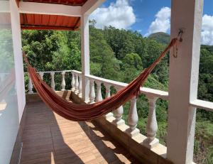 a hammock on the balcony of a house at Bangalô - Sítio Cachoeiras do Caledônia in Nova Friburgo