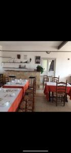 un comedor con mesas y sillas con mantel rojo en Hotel Les Calanques, en Piana 18 fotos más