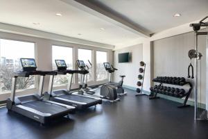 a gym with treadmills and machines in a room at Sol Cypress, San Antonio, a Tribute Portfolio Hotel in San Antonio