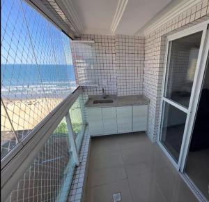 a bathroom with a sink and a view of the beach at AP beira mar in Praia Grande