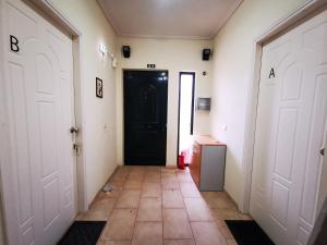 a hallway with a black door and a tile floor at Studio Apartments Eirini in Pyrgi Thermis