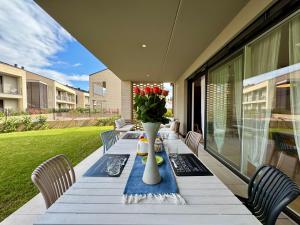 a long table with a vase of flowers on a patio at Borgo Garda in Peschiera del Garda