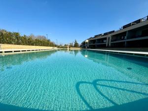 a large pool of blue water with the shadow of a person at Borgo Garda in Peschiera del Garda