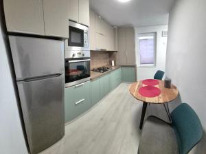 a kitchen with a small table and a refrigerator at Tudor Central Apartment in Bistriţa