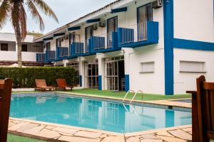 a hotel with a swimming pool in front of a building at MOVA - Hotel Costa Azul in Ubatuba