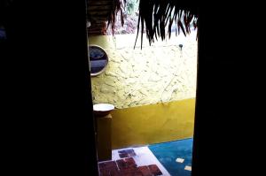 a view of a bathroom with a yellow wall at Lazy Hut in Ko Phayam