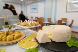 a table with two plates of food and a cake at Hotel St Gregory Park in Rimini