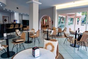 a restaurant with tables and chairs in a room at Hotel St Gregory Park in Rimini