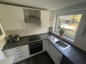 a small kitchen with a sink and a window at Goorn Hus, Ferienhaus in Schneverdingen
