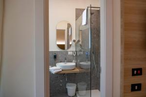 a bathroom with two sinks and two mirrors at Hotel St Gregory Park in Rimini