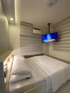 a bedroom with a bed with a tv on the wall at Elegant Escape Milano Bacoor Cavite in Bacoor