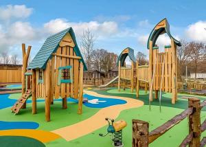 a playground with wooden play equipment in a park at Norfolk Woods Resort And Spa in Narborough +35 photos