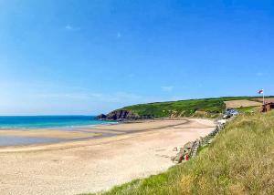 a sandy beach with the ocean in the background at Stream Valley Holiday Park in Penzance