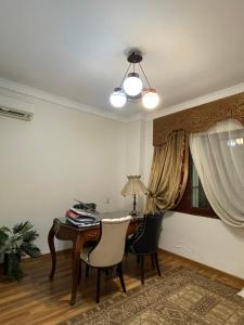 Habitación con escritorio con 2 sillas y lámpara. en Zayed Villa, en Sheikh Zayed