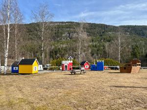 a park with a playground with a bench and houses at Sanda Camping og Hytteutleie in Øvrebø +38 photos