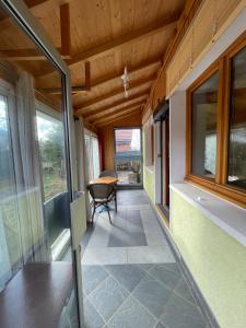 - un couloir d'une maison avec une table et des fenêtres dans l'établissement Chalet type pagotin rénové au coeur, à Métabief