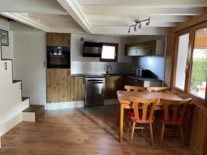 une cuisine avec une table et des chaises en bois dans l'établissement Chalet type pagotin rénové au coeur, à Métabief 2 autres photos