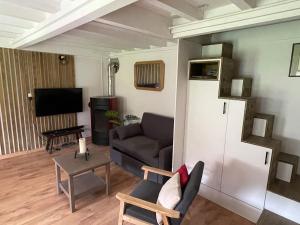 un salon avec un canapé et une télévision dans l'établissement Chalet type pagotin rénové au coeur, à Métabief