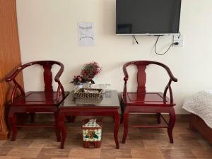 two chairs and a table with a tv on a wall at Công Thành hotel in Lao Cai
