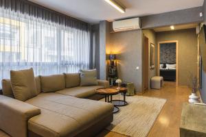 a living room with a couch and a large window at City Center Apartments with Parking in Plovdiv