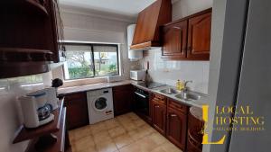 a small kitchen with a sink and a dishwasher at Golden Algarve Apartament By Localhosting in Albufeira