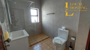a bathroom with a white toilet and a sink at Golden Algarve Apartament By Localhosting in Albufeira +6 photos