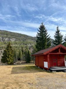 een kleine rode hut midden in een veld bij Sanda Camping og Hytteutleie in Øvrebø