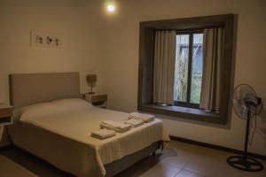 a bedroom with a bed and a window with towels on it at Comarca Andina in Ciudad Lujan de Cuyo +97 photos