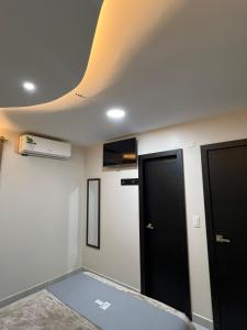 a room with two doors and a ceiling at Hotel Tonaka in Santo Domingo de los Colorados +2 photos