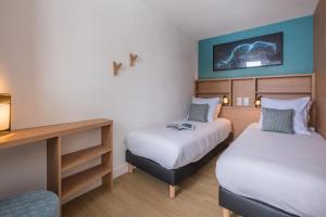 En eller flere senge i et værelse på Résidence Pierre & Vacances Capella